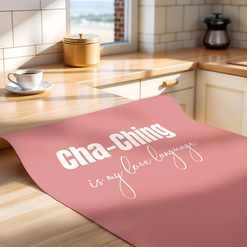 Pink poster with 'Cha-Ching is my love language' text on a kitchen counter.