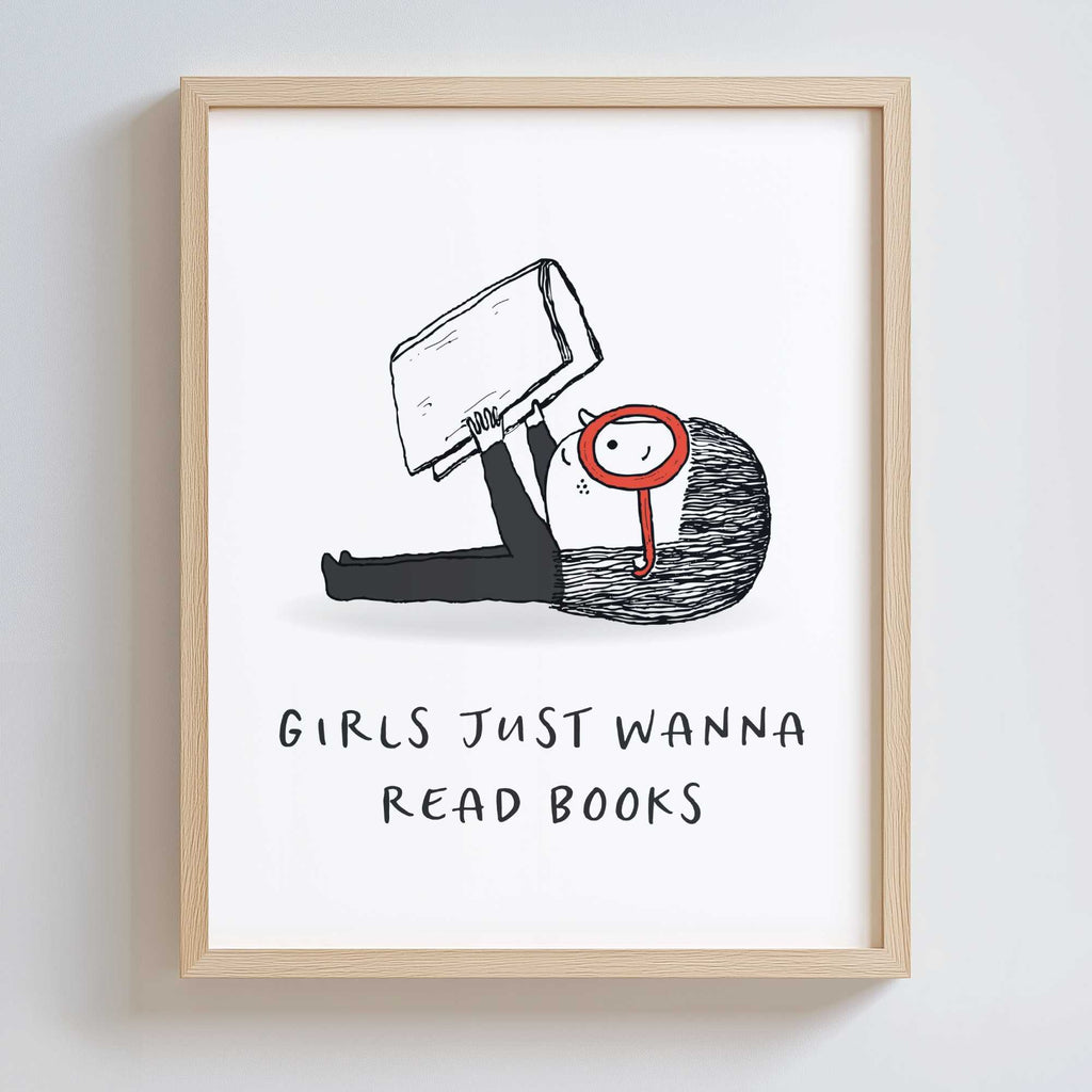 Wood-framed artwork with a black and white illustration of a girl holding a book and wearing large red glasses. Text underneath says 'GIRLS JUST WANNA READ BOOKS'.