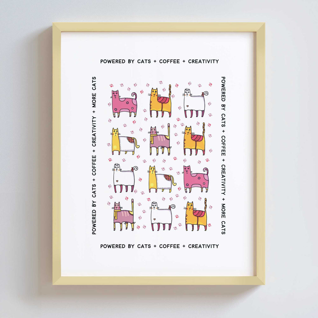Framed print with colorful cat illustrations and text 'Powered by Cats + Coffee + Creativity'