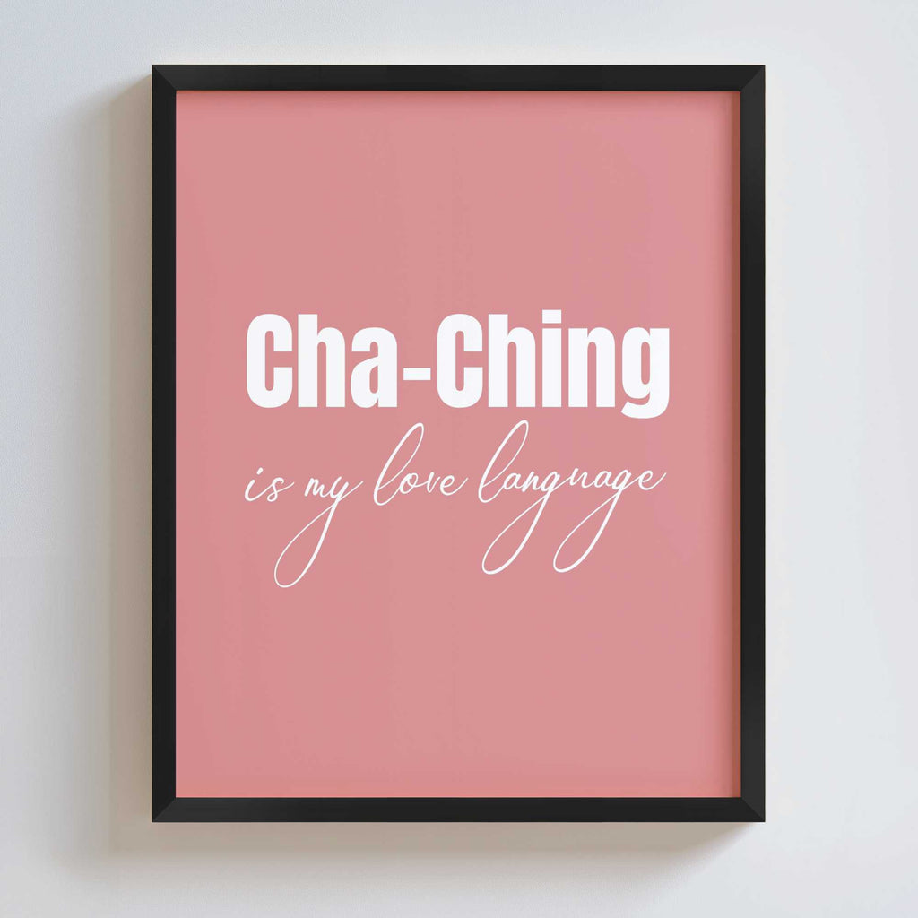 Framed pink poster with 'Cha-Ching is my love language' text on a white wall.