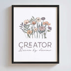Black frame displays artwork with floral design and text 'CREATOR Driven by dreams.' on a white background