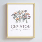 Artwork in a gold metal frame with floral design and text 'CREATOR Driven by dreams.' on a white background
