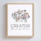 Framed artwork with floral design and text 'CREATOR Driven by dreams.' on a white background