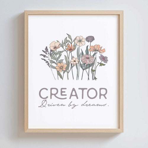 Framed artwork with floral design and text 'CREATOR Driven by dreams.' on a white background