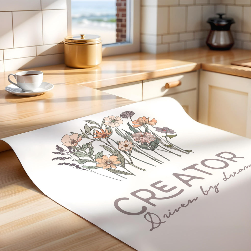 Floral design on an unframed print with text, lying on a kitchen counter.