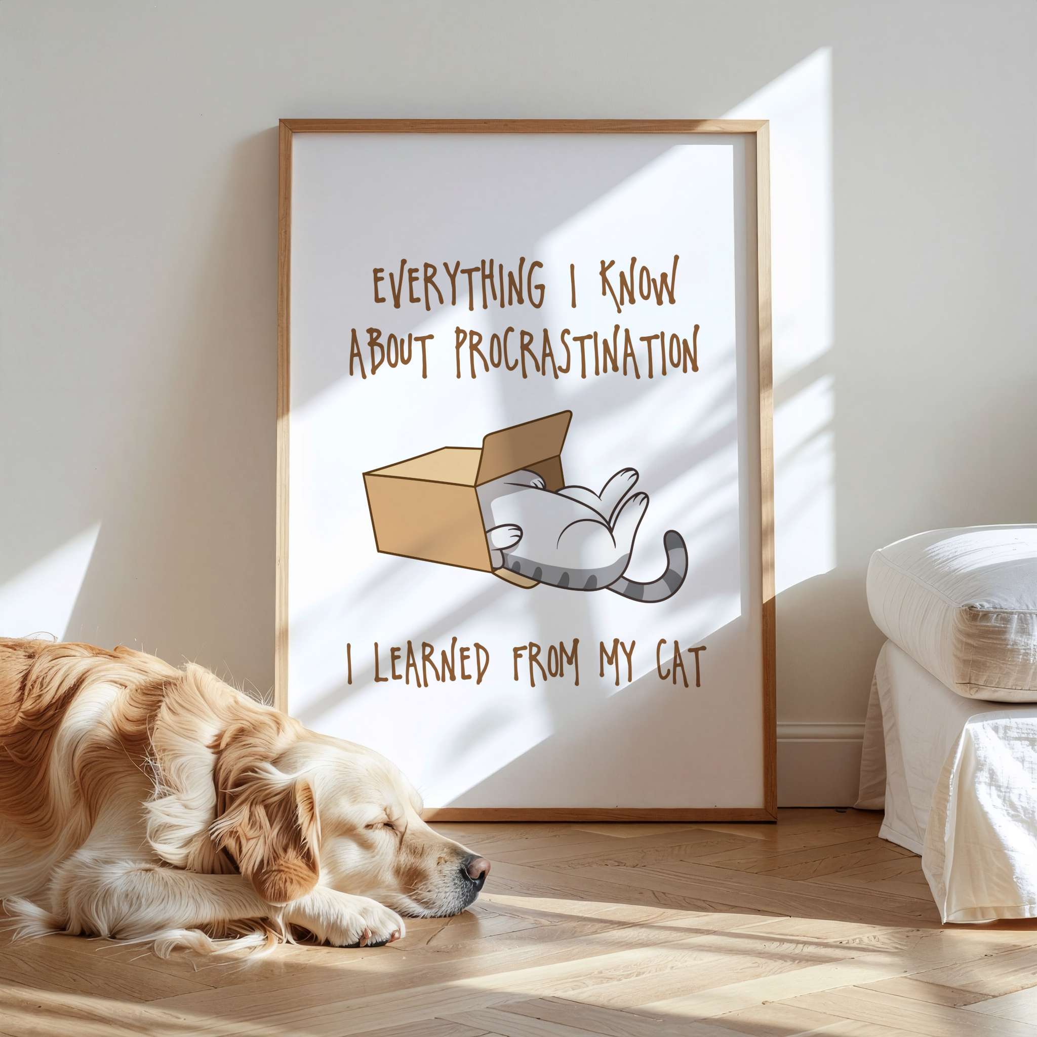 Dog lying on a wooden floor next to a framed picture of a cat in a box and humorous text.