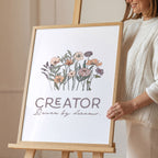 Young woman holding a framed artwork with floral design and text on an easel.