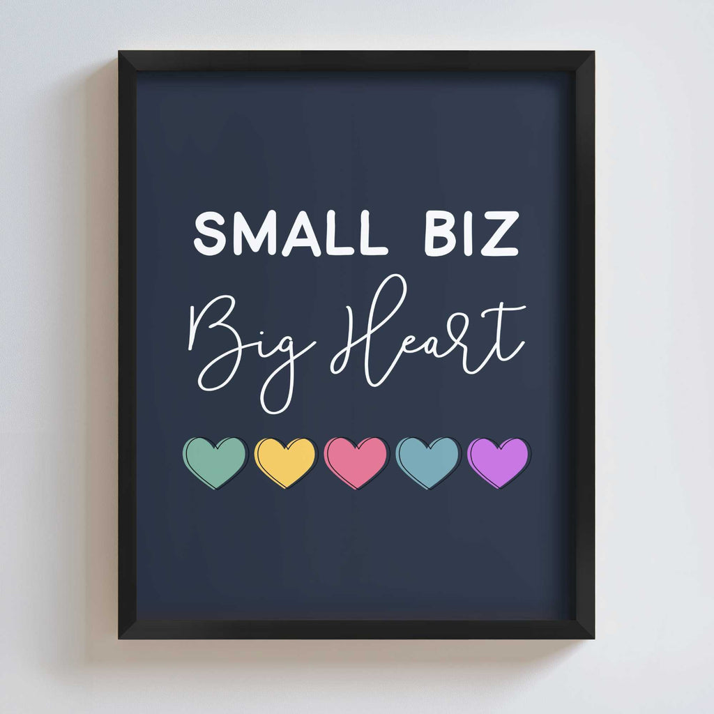 Framed artwork with 'Small Biz Big Heart' text and colorful hearts on a dark blue background.