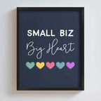 Framed artwork with 'Small Biz Big Heart' text and colorful hearts on a dark blue background.