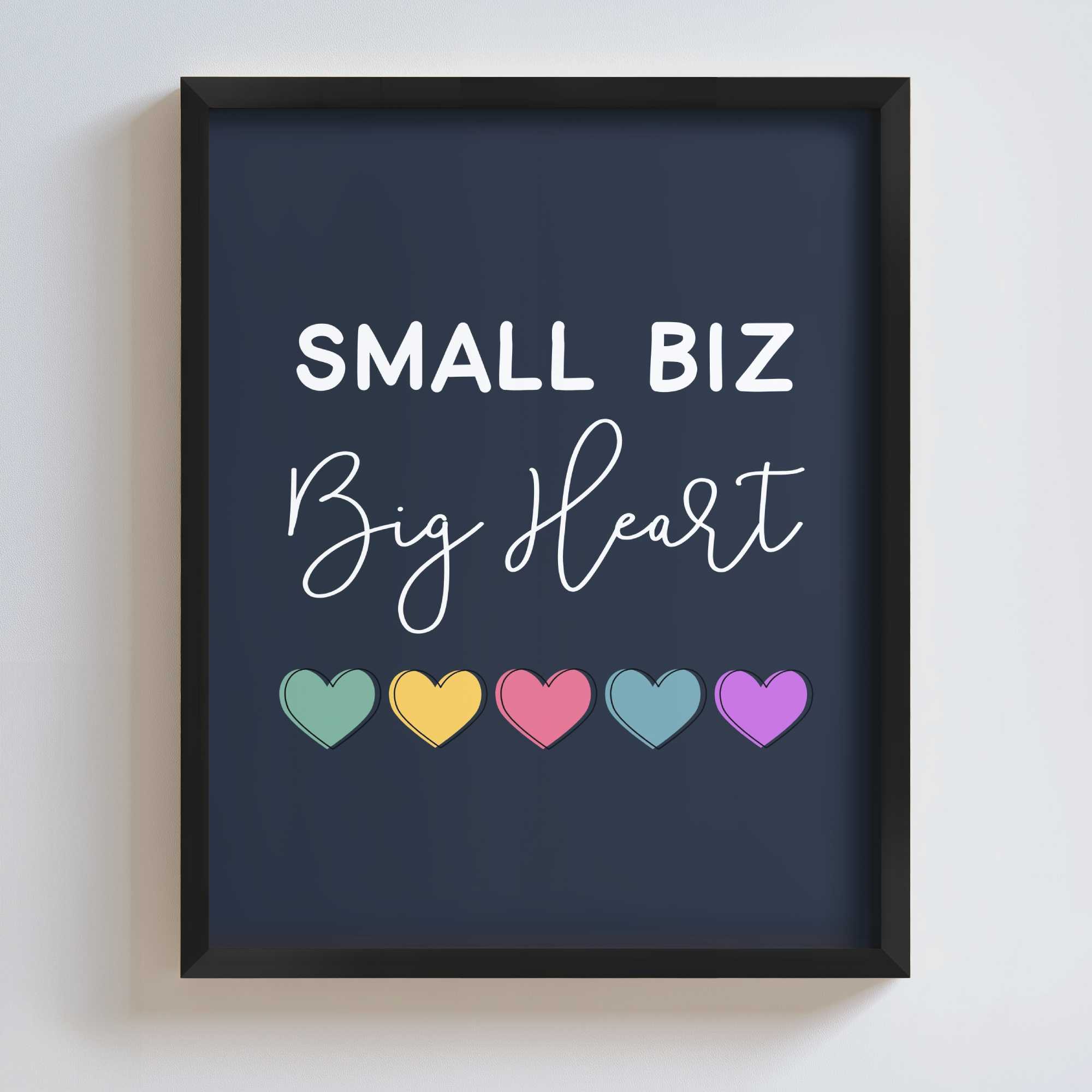 Framed artwork with 'Small Biz Big Heart' text and colorful hearts on a dark blue background.